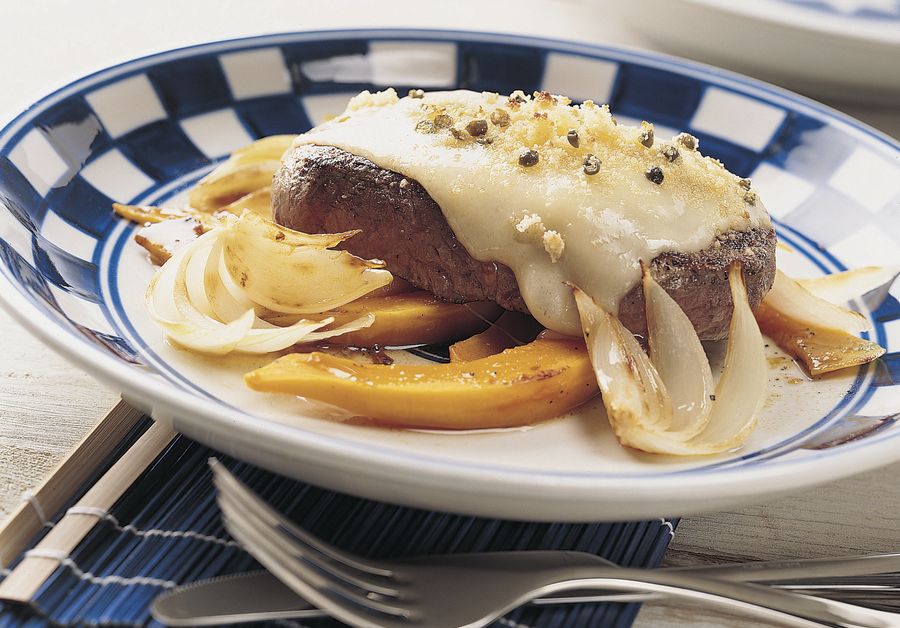 Bistecca al formaggio e al pepe su letto di cipolle e zucca